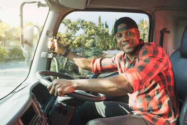 Truck Driver man African American muscular smiling, in long-time business transportation and delivery. Trust by customers  provide professional service and safety in transport Truck Insurance cargo.