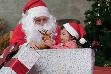 Küçük kız çocukluğunda mutlu bir gülümseme Noel Baba amcasının hediye kutusundan memnundu. Festival kutlaması. Mutlu Noeller Yeni yıl konsepti