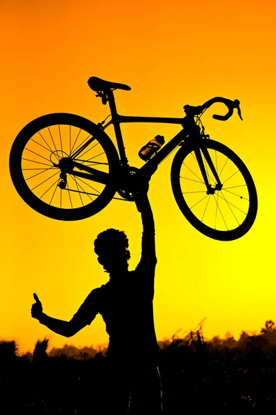 A cyclist raising his bike — Stock Photo, Image