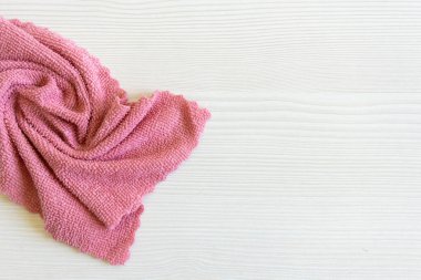 Açık pembe mikrofiber dokuyu kapatın. Masanın üzerindeki bezi temizliyorum. Ev kavramı