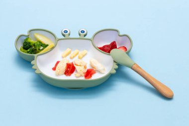 Sütten kesilme, blöf. İlk bebek maması. Karışık sebzeli silikon tabak. Çocuk için sağlıklı beslenme, kendini besleme. Yumuşak eko plastik sofra takımı. - Evet. Yüksek kalite fotoğraf
