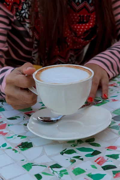 Junge Frau im Café nippt an Kaffee aus einer Tasse — Stockfoto