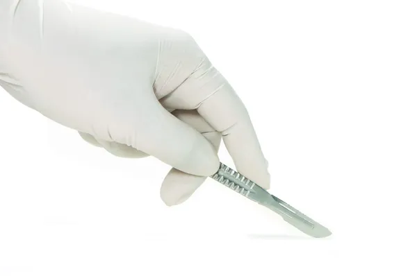 Scalpel in a hand with rubber glove Royalty Free Stock Images