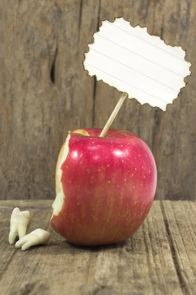 Teeth against red apple — Stock Photo, Image