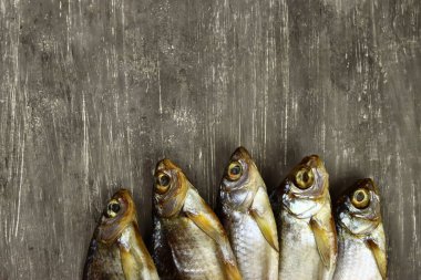 Kurutulmuş tuzlanmış balık, bira aperatifi, hamamböceği ve Rudd gri arka planda.
