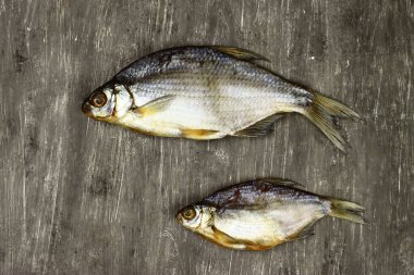 Gri arka planda kurutulmuş balık, bira atıştırmalığı.