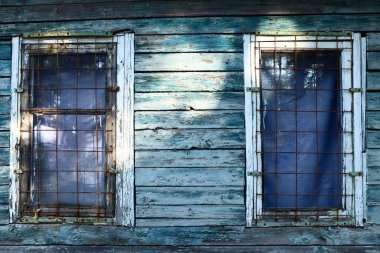 Ahşap bir evde kafesli eski kirli pencereler.