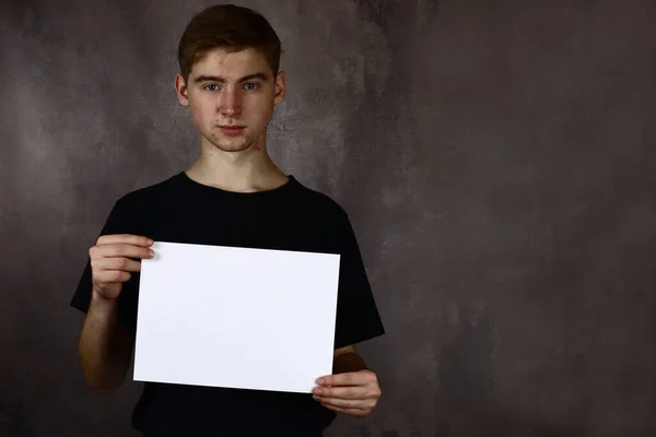 Jonge Man Met Een Leeg Vel Papier Voor Tekst — Stockfoto