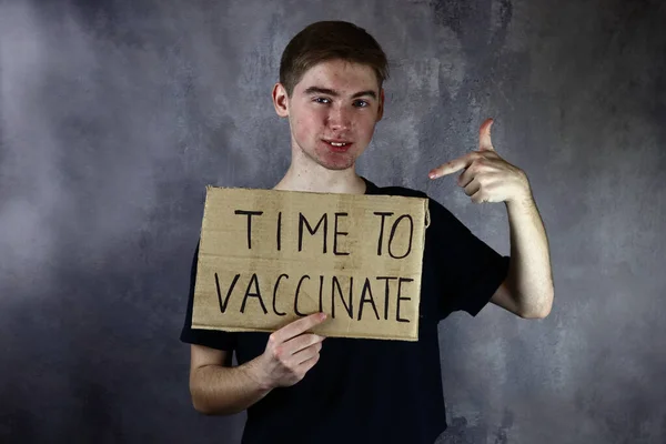 有海报的年轻人是时候接种疫苗了 — 图库照片
