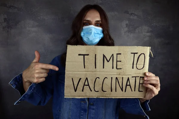 ポスターを予防接種する時間のある医療マスクの若い女性 — ストック写真