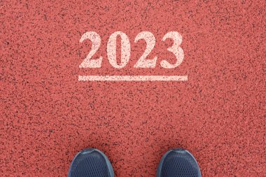 Bacaklar 2023 yazısının önünde duruyor. Yeni yıl konsepti