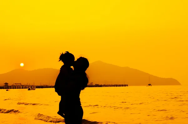 Silhouettes of mother and baby kissing on sunset — Stock Photo, Image