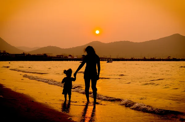 Silhouette of mother and baby walking on sunset — Stock Photo, Image