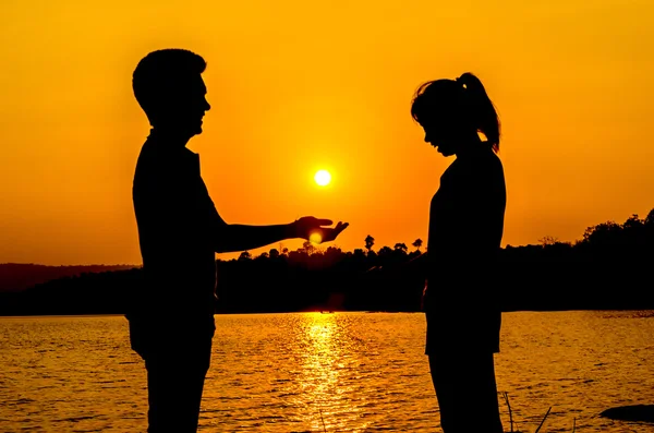 Silueta pareja en la orilla del lago — Foto de Stock