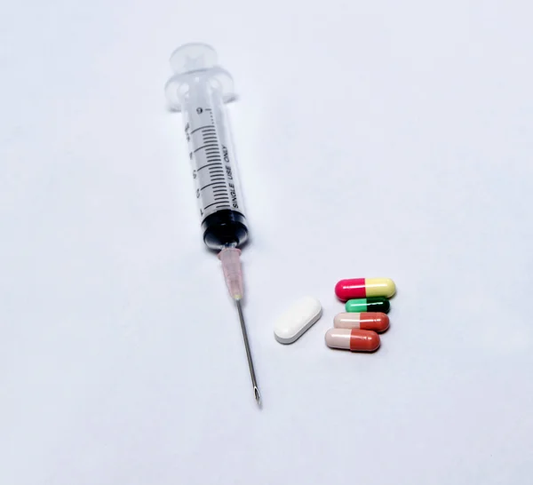 Detail lékařskou stříkačkou tablety a kapsle — Stock fotografie