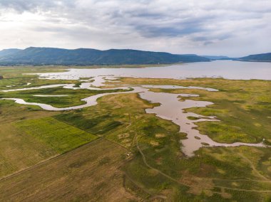 Nehir ve havzanın doğal bir dağa karşı manzaralı manzarası, Drone gürültülü ve tahıl işlenmiş tropikal araziyi vurdu.