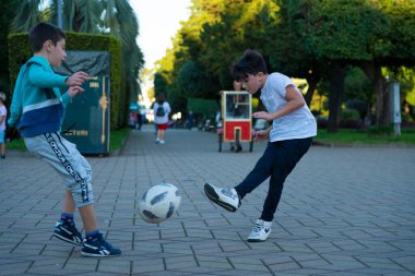 Batumi, Georgia - 9 Ekim 2021: Çocuklar ve yetişkinler parkta futbol oynuyor