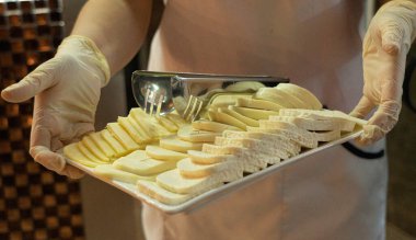 Garson bir dilim peynir taşıyor.