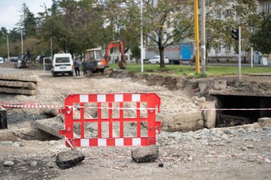 Kazılmış çukurun önünde çit var.