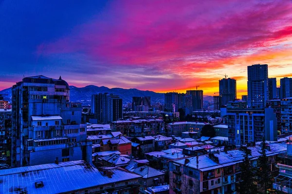 Karlı şehrin üzerinde güzel pembe gün batımı