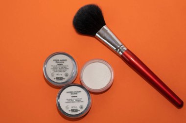 Batumi, Gürcistan - 10 Şubat 2022: Turuncu arkaplanda barut ve fırça bulunan kavanozlar