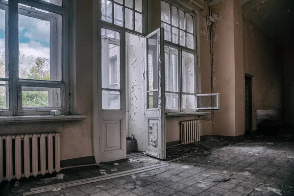 放棄された病院のドアのある美しい廊下 窓の外の通り 古いみすぼらしい壁 放棄された建物の内部 木造扉 — ストック写真