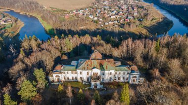 Beyaz duvarları olan terk edilmiş eski güzel bir malikane. Güzel sonbahar manzarası. Eski gotik mimari. Ormanda güzel bir bina..