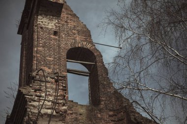 Terk edilmiş bir çan kulesinin tuğla duvarı. Eski terk edilmiş mimari. Mavi gökyüzü. Unutulmuş çan kulesinin tuğla duvarı.