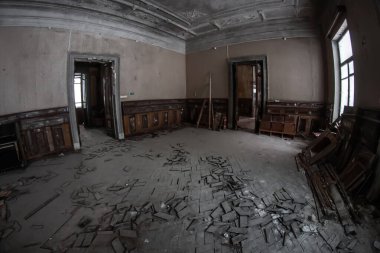 Terk edilmiş eski bir evde yüksek kapıları olan kasvetli bir oda. Eski püskü duvarlar ve güzel bir tavan. Duvarlarda küf var. Terk edilmiş eski bir malikane.