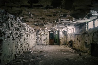 Sefil duvarları olan güzel ve korkunç bir koridor. Terk edilmiş bina. Duvardaki kalıplı pencereden gelen ışık. Eski kırık bir kapı. Korkunç terk edilmiş malikane..