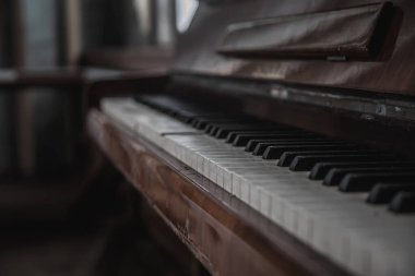 Terk edilmiş bir binada eski bir piyano. Güzel bir müzik aleti. Anahtarları olan eski siyah terk edilmiş piyano..