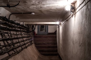 Terk edilmiş bir yeraltı sığınağında eski püskü duvarları olan güzel bir koridor. Eski yeraltı binası. Eski püskü duvarlar. Düşük ışık.