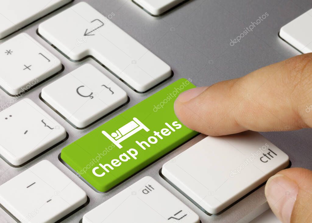 Cheap hotels Written on Green Key of Metallic Keyboard. Finger pressing key.