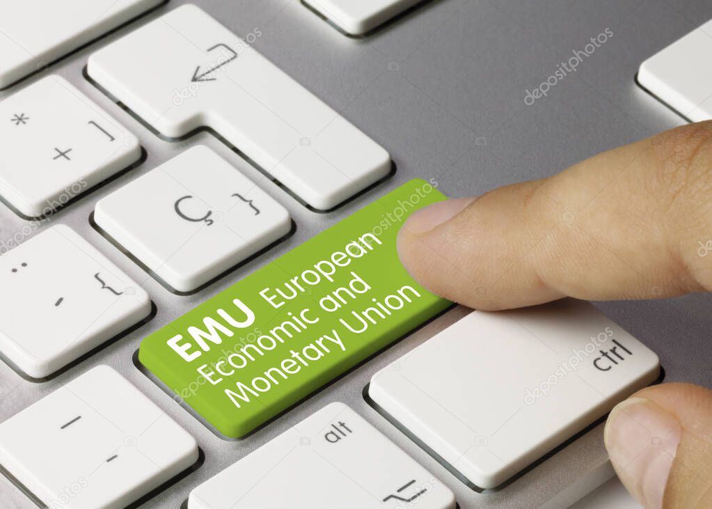 EMU European Economic and Monetary Union Written on Green Key of Metallic Keyboard. Finger pressing key.