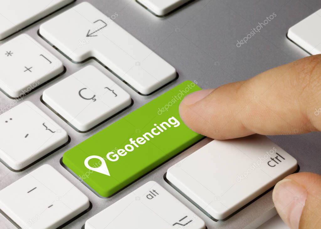 Geofencing Written on Green Key of Metallic Keyboard. Finger pressing key.