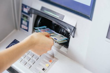 Bir kadının elini bankamatik makinesinden nakit para çekerken yaklaş. Finans müşterisi ve bankacılık hizmeti kavramı