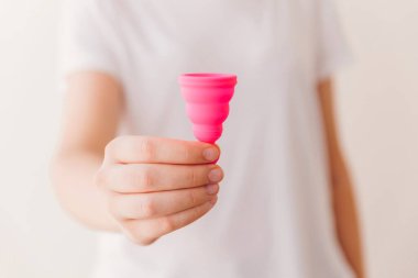 Unrecognizable woman showing a menstrual cup close up view. Zero waste, eco and reusable alternatives for period and female hygiene concept