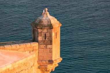 Gün batımında denize karşı Santa Barbara Kalesi, Alicante, İspanya.