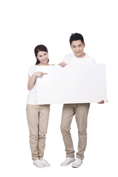 Casal segurando um sinal em branco — Fotografia de Stock