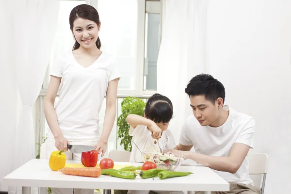 Família que prepara uma salada — Fotografia de Stock