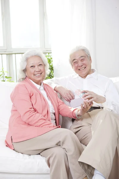Oudere echtpaar met geschenkdoos — Stockfoto