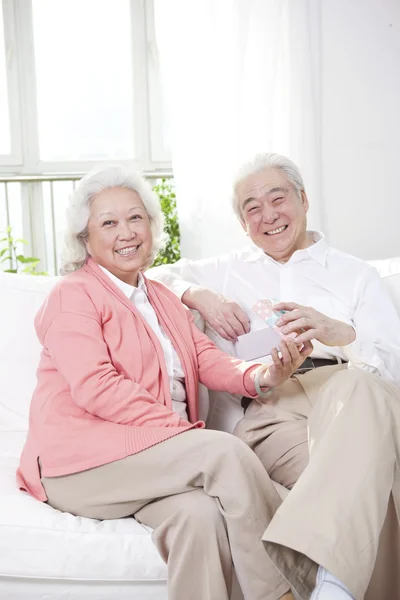 Pareja mayor sosteniendo caja de regalo —  Fotos de Stock