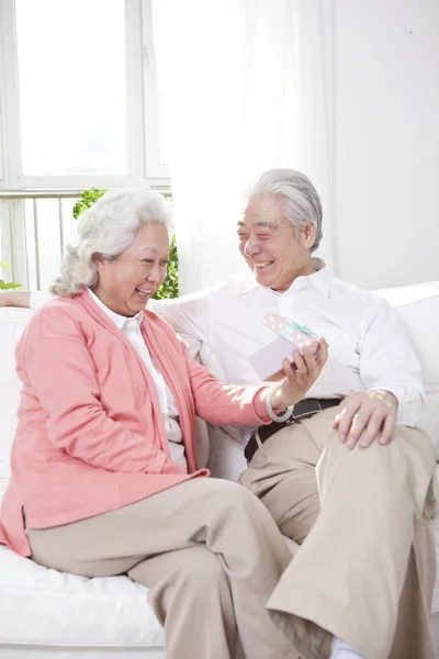 Oudere echtpaar met geschenkdoos — Stockfoto