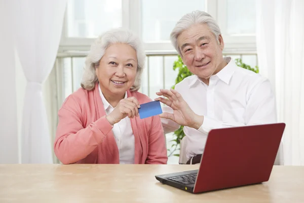 Senior couple holding credit card — Stock Photo, Image