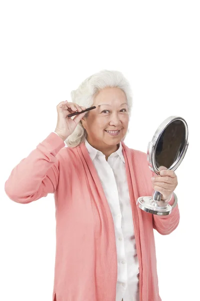 Senior woman holding mirror — Stock Photo, Image