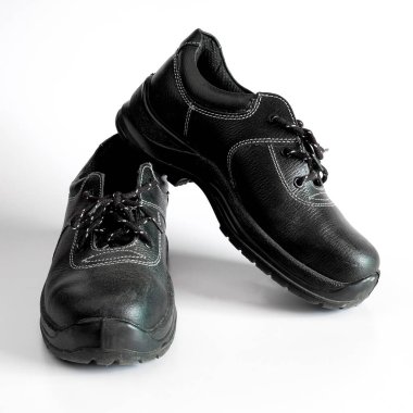 Arka planda siyah ve kirli bir çift çocuk ayakkabısı.