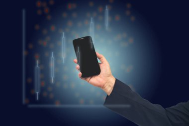 Hand holding smartphone looking at Stock exchange trading data information displayed symbol. Investor and trader concept.