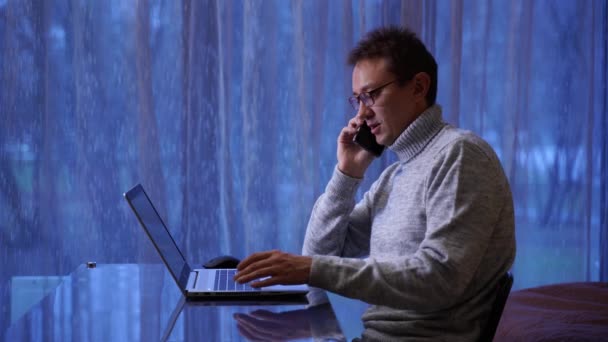Hombre freelancer concentrado en anteojos trabajando remotamente en casa Video de stock
