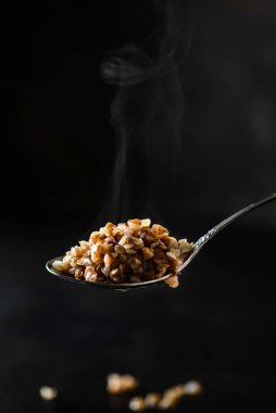 Koyu arkaplanda kaynamış karabuğdaylı kaşık. Yüksek kalite fotoğraf