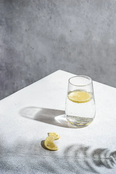 灰色の背景にレモンと水 高品質の写真 — ストック写真